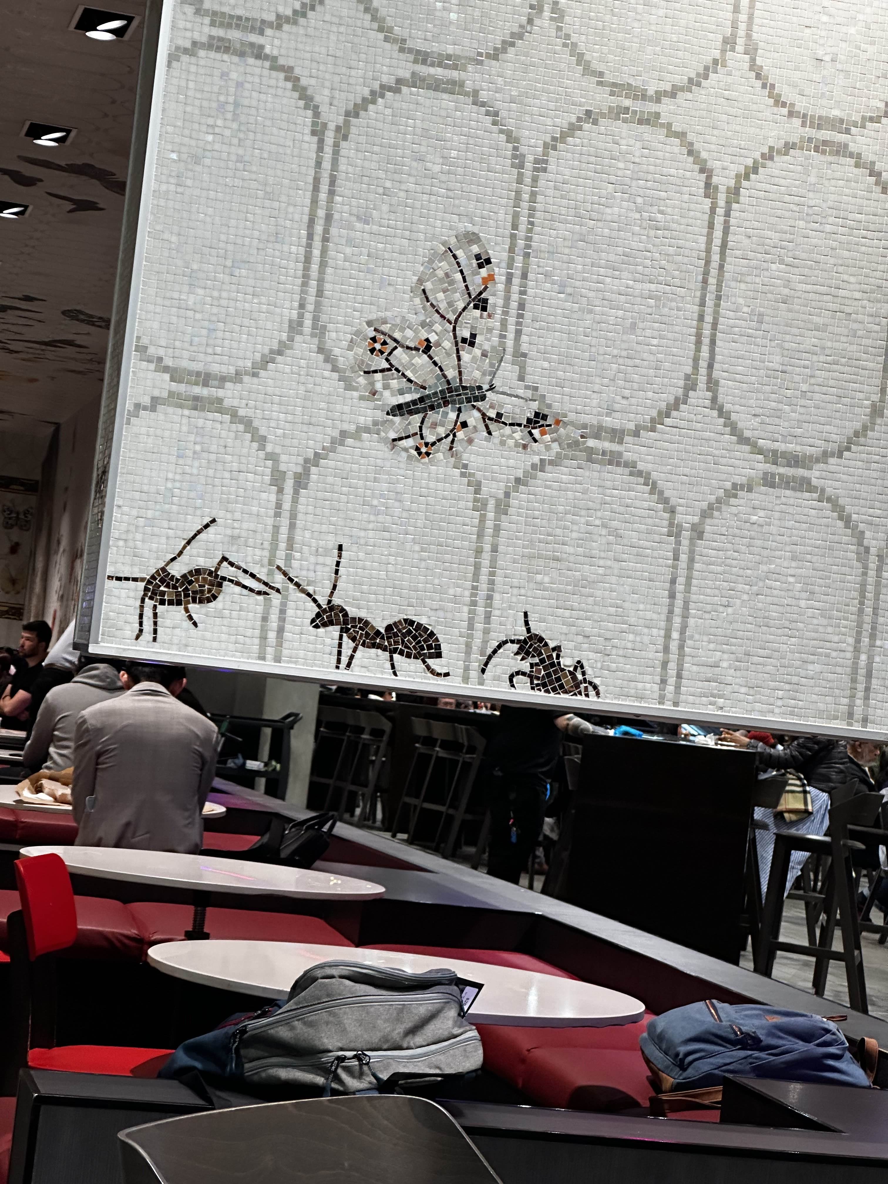 Picture of a wall mosaic in a food court of three ants