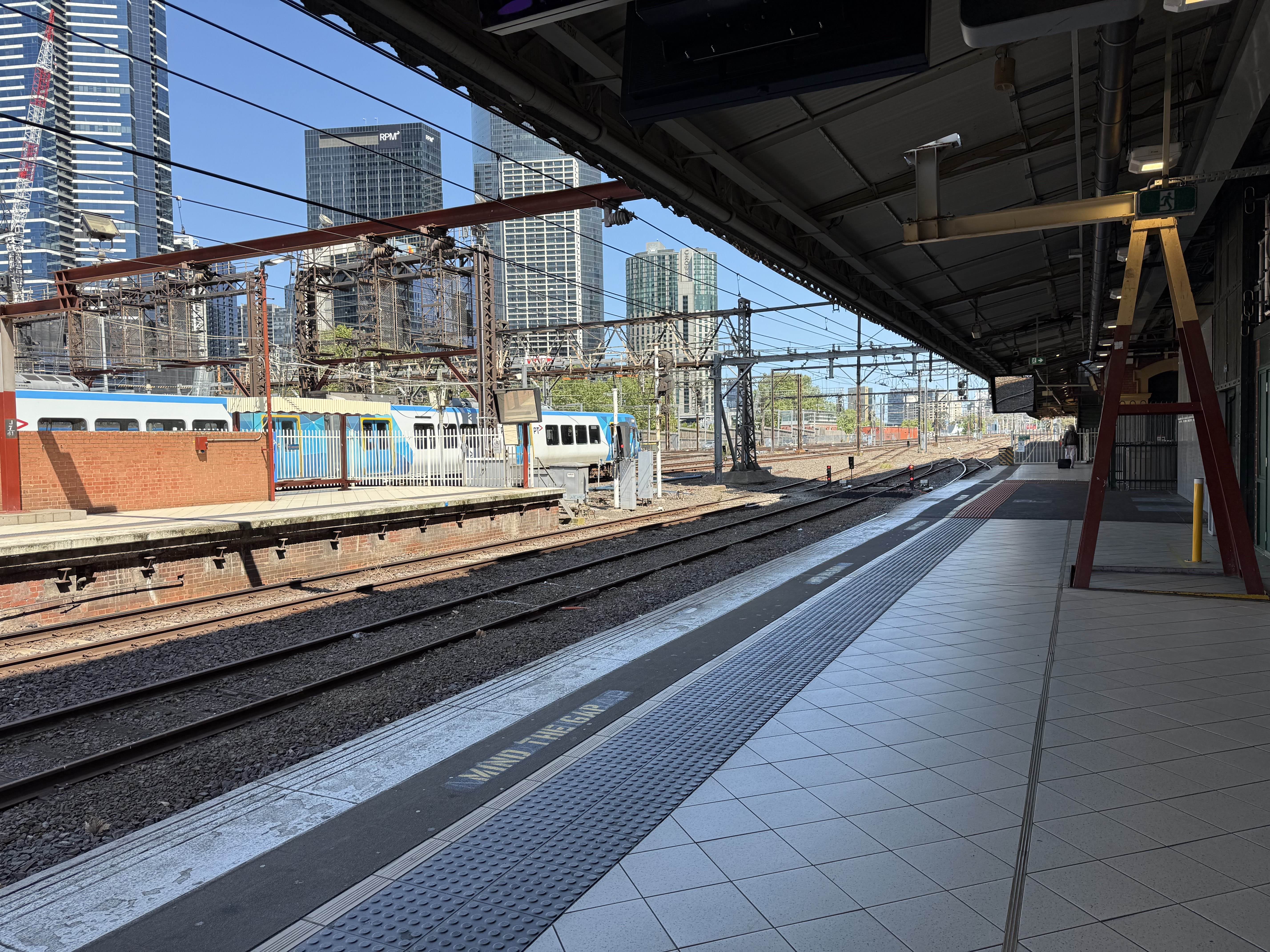 Picture of a platform at Flinders Street station with a train in the background